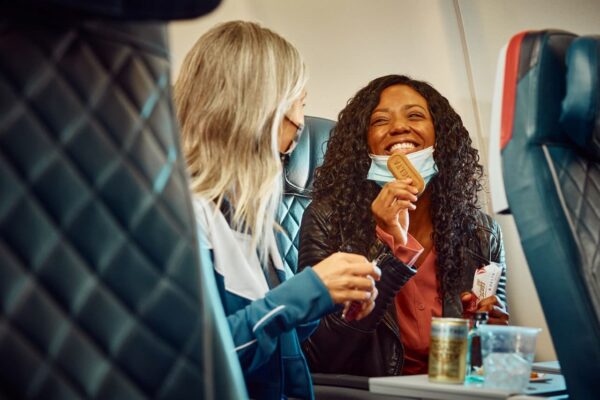 Grupo de personas en un avión comiendo. Es posible comer con seguridad e higiene